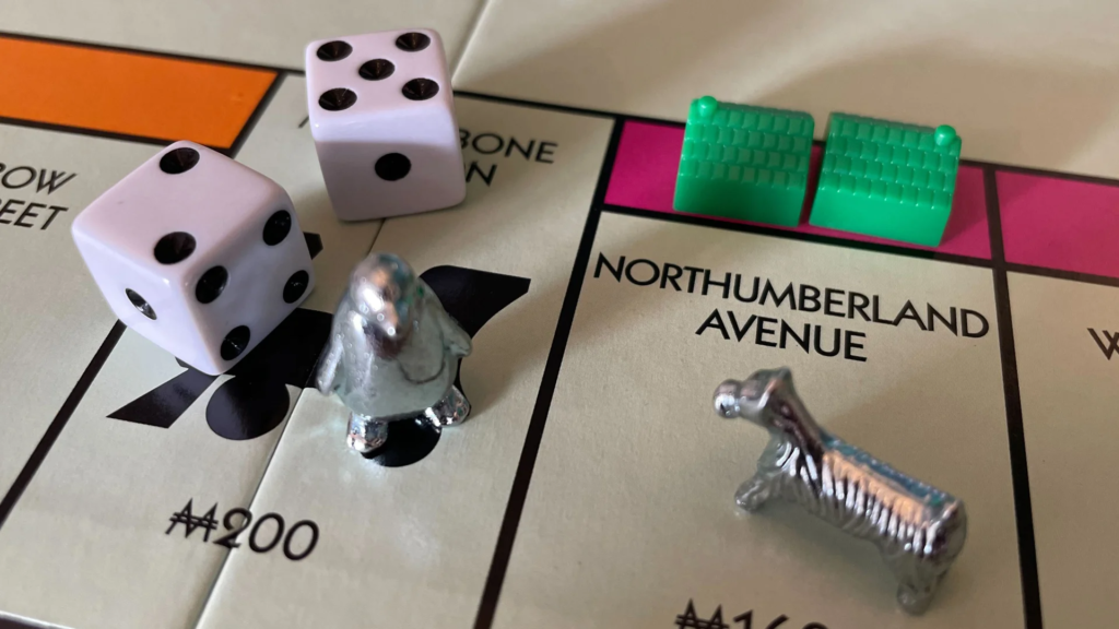 Close-up of a Monopoly board with a player piece and dice, ready for gameplay, symbolizing strategy and decision-making in the game.