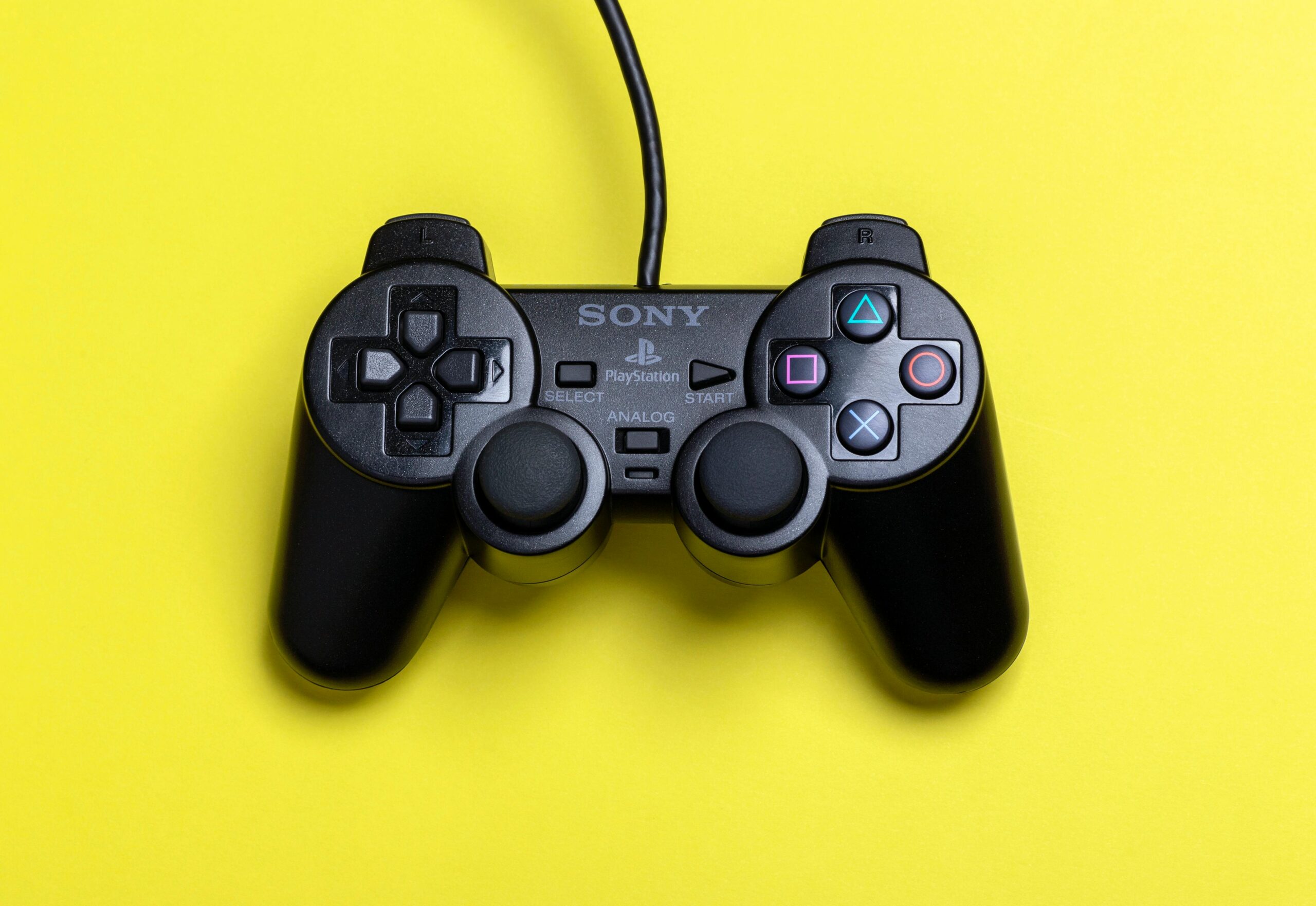 PlayStation DualShock controller on a yellow background