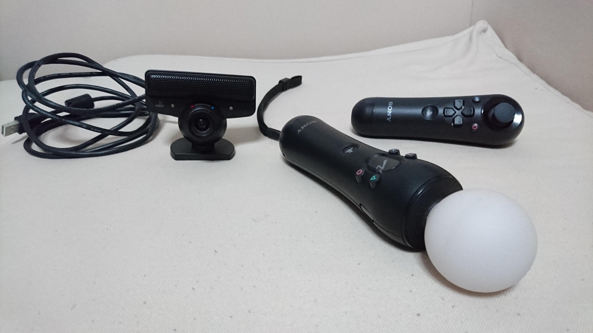 PlayStation Move controllers and PlayStation Eye camera laid out on a surface