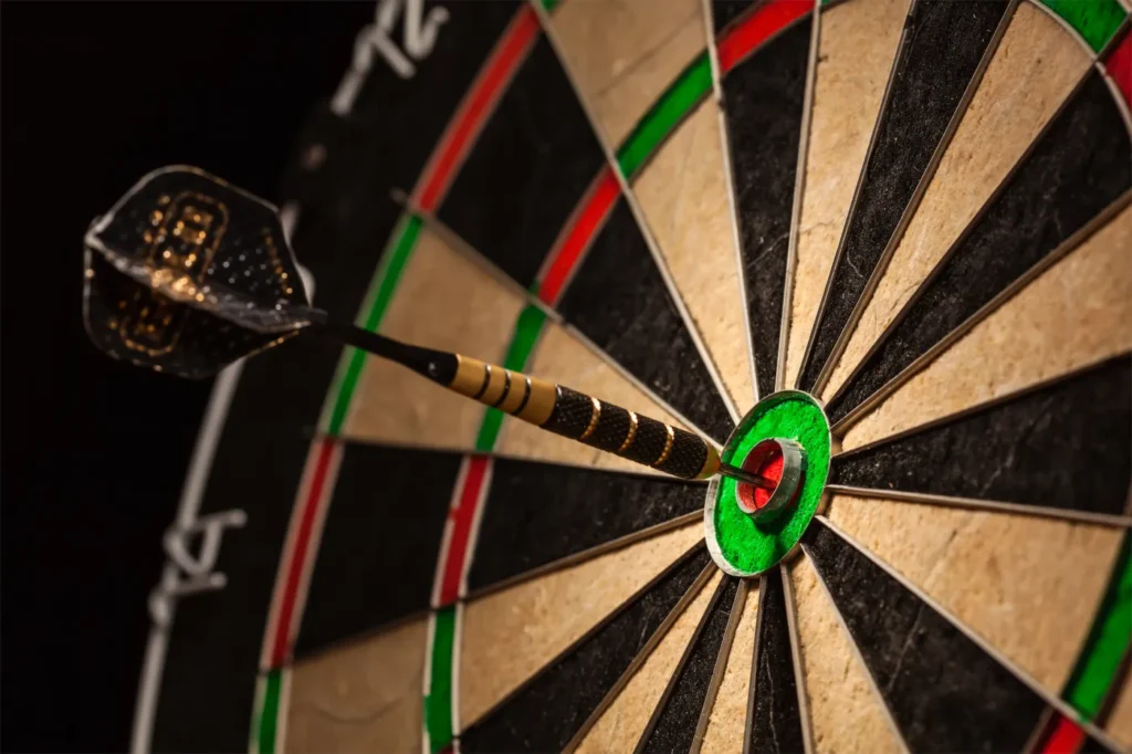 Close-up of a dart hitting the bullseye on a professional dartboard.