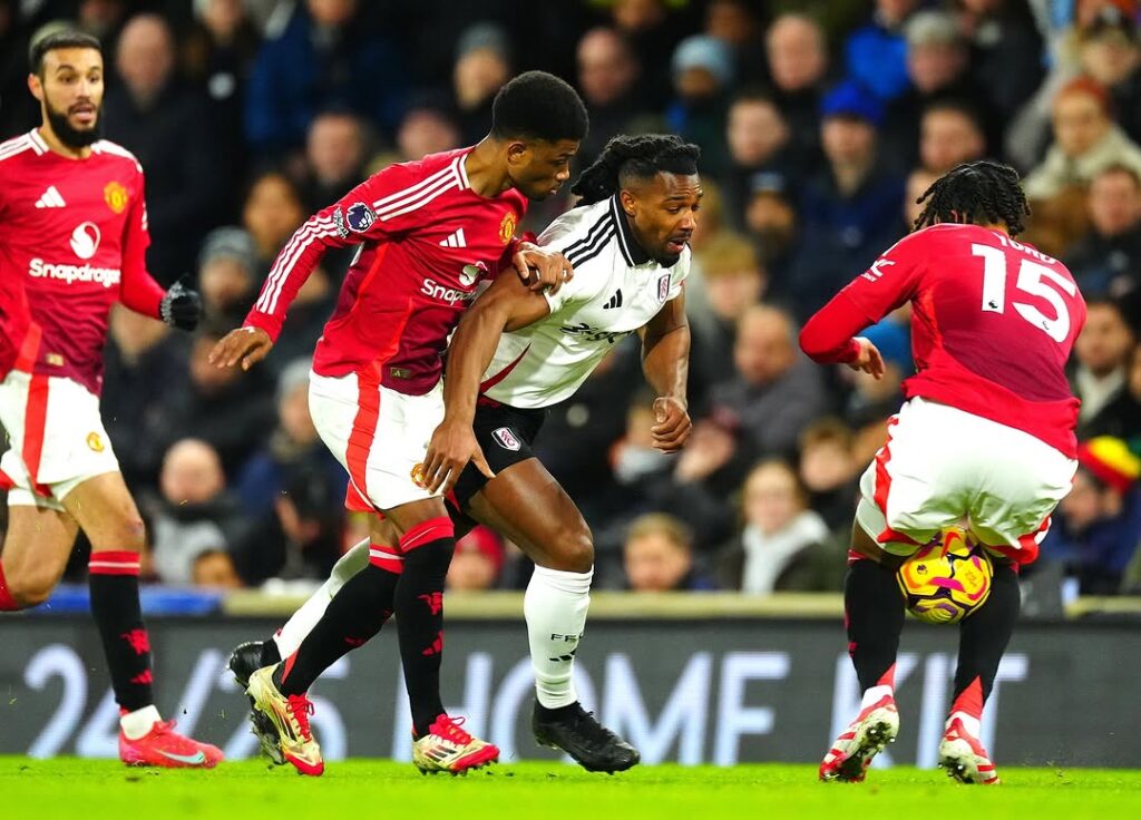 Premier League players battling for possession during a high-intensity Manchester United vs Fulham match