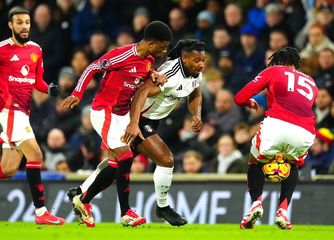 Premier League players battling for possession during a high-intensity Manchester United vs Fulham match