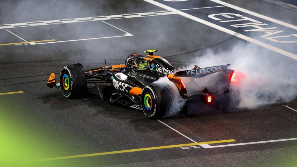 Lando Norris spinning his Formula 1 car in celebratory doughnuts on the track after clinching the 2025 championship.