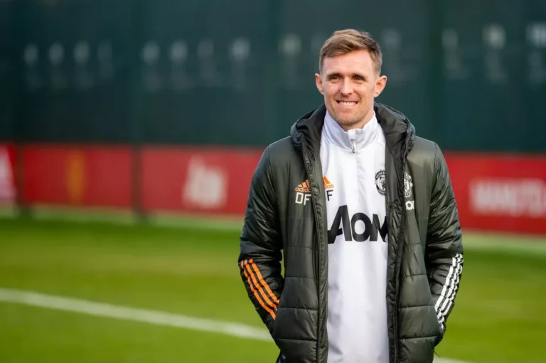 Darren Fletcher wearing Manchester United coaching gear on the sidelines during his previous tenure with the first team, focused on guiding players.
