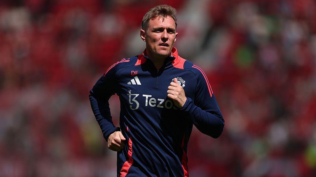 Darren Fletcher running during a Manchester United training session, demonstrating fitness and active coaching involvement with the team.