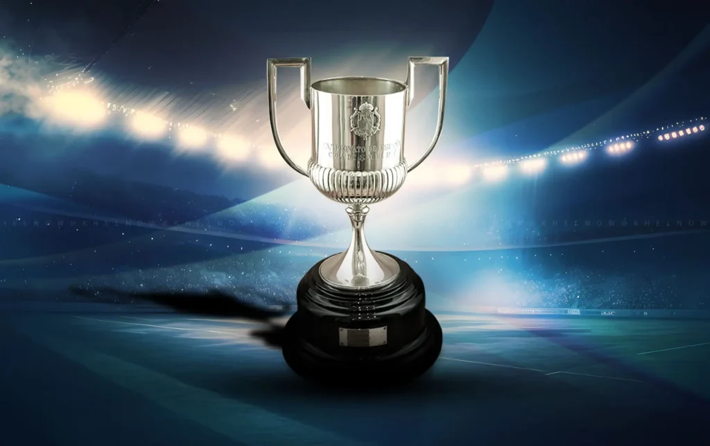 Copa del Rey trophy on display inside a stadium with bright lights in the background